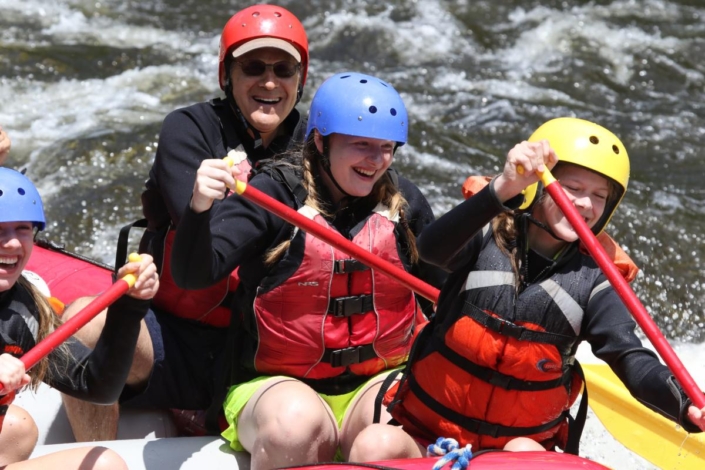 Happy granddaughters paddling with their grandpa